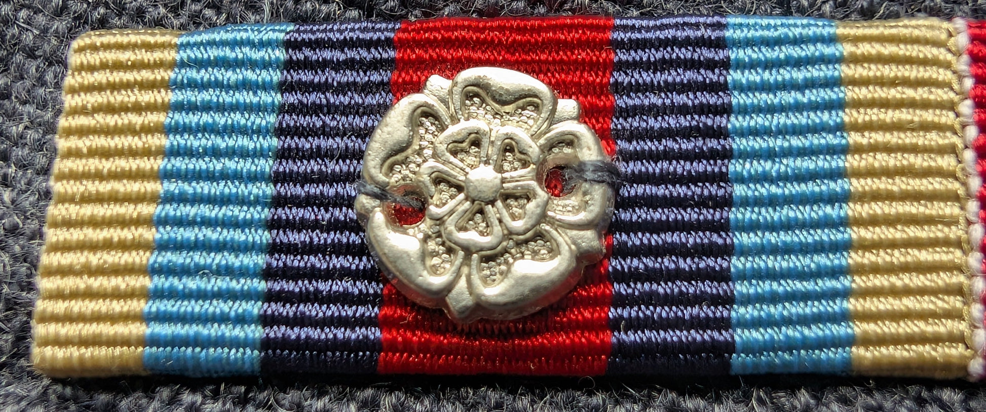 Colorful ribbon with a decorative emblem on a textured surface
