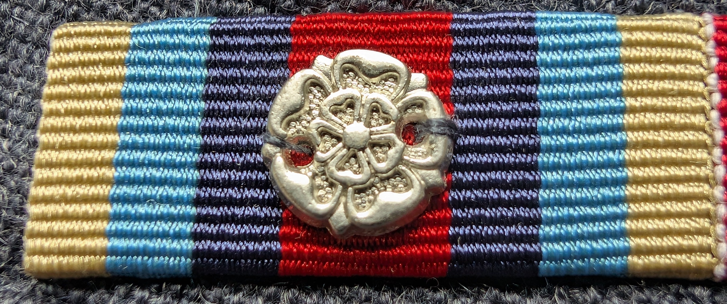 Colorful ribbon with a decorative emblem on a textured surface