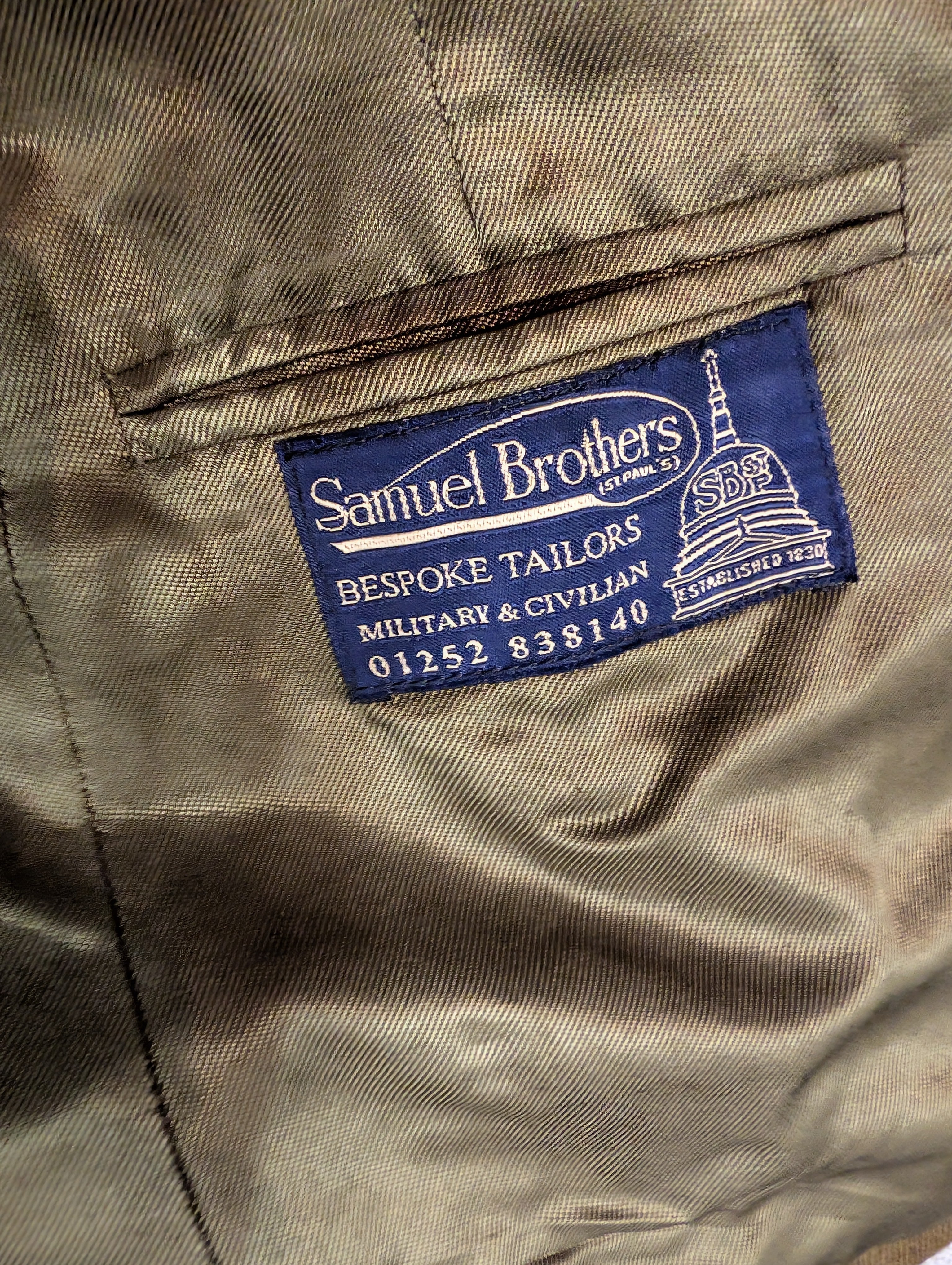 Close-up of a satin-like taupe garment interior with a blue fabric brand label reading Samuel Brothers Bespoke Tailors on a 1980s Pattern British Army Officers No2 Service Dress Uniform Jacket & Skirt