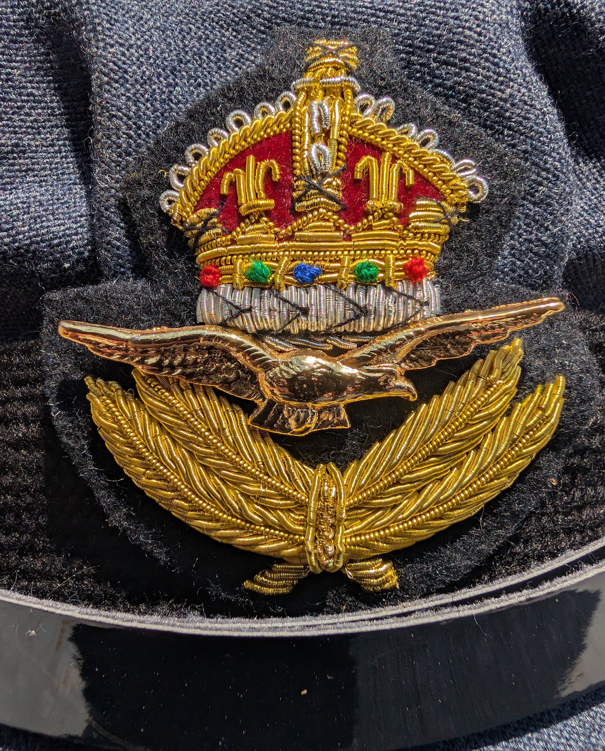 Close up view of GVIR Kings Crown Cap Badge on as RAF WAAF No1 Uniform Repro WWII Peak Cap WW2 WRAF Hat 1940s